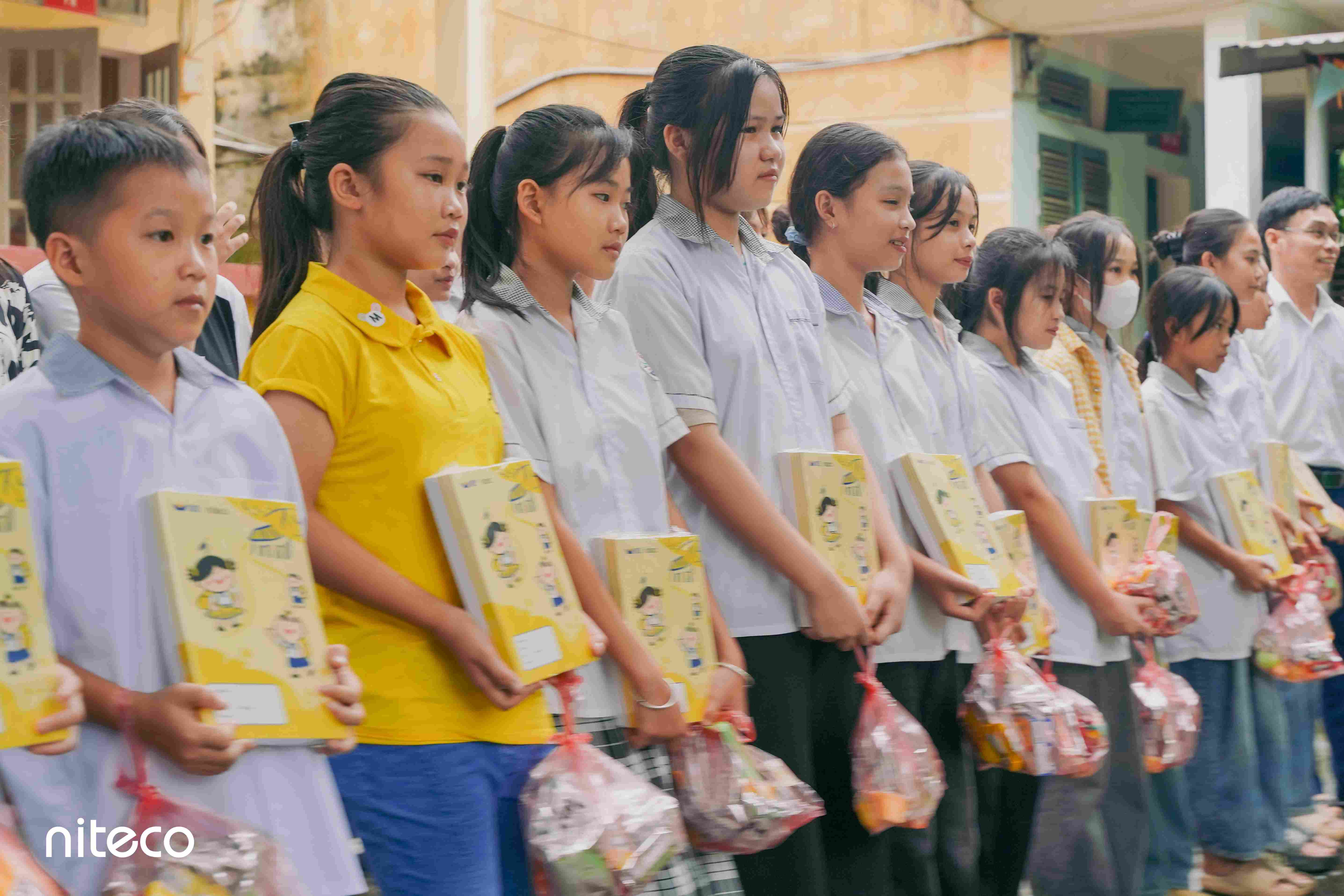 Students receiving educational gifts and supplies during school charity event
