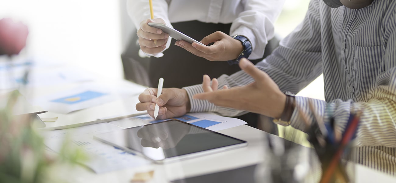 Hands interacting with tablet and smartphone during business digital marketing discussion
