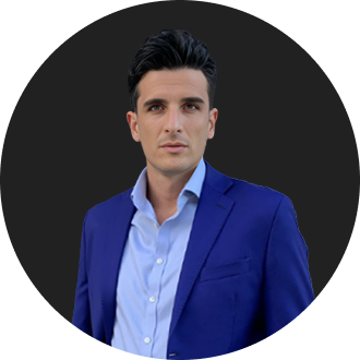 Young professional man in blue suit with confident expression against black background