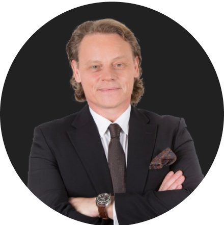 Confident businessman in black suit with arms crossed and watch visible