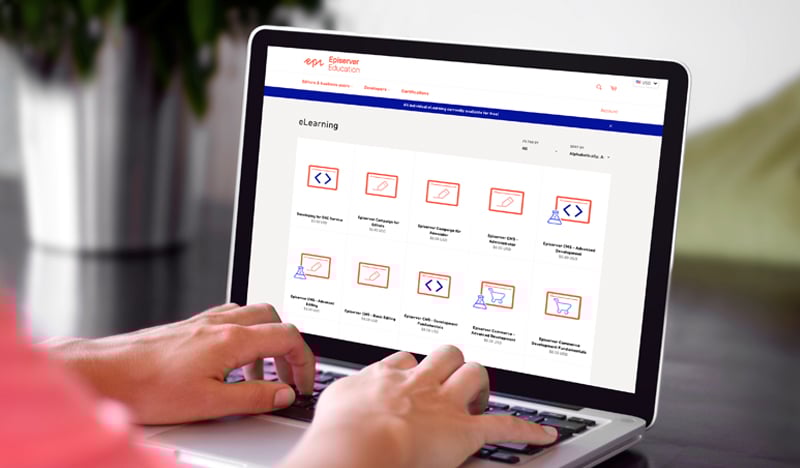 Hands navigating Optimizely Education eLearning courses on a laptop screen