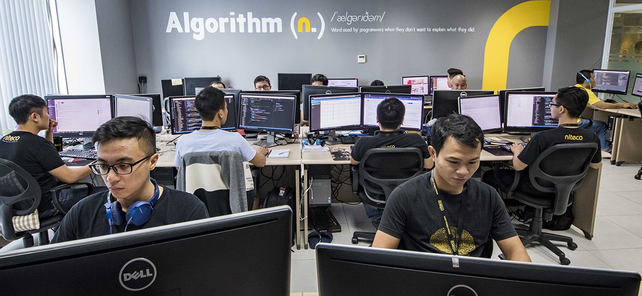 Programmers coding algorithms in a collaborative tech office workspace