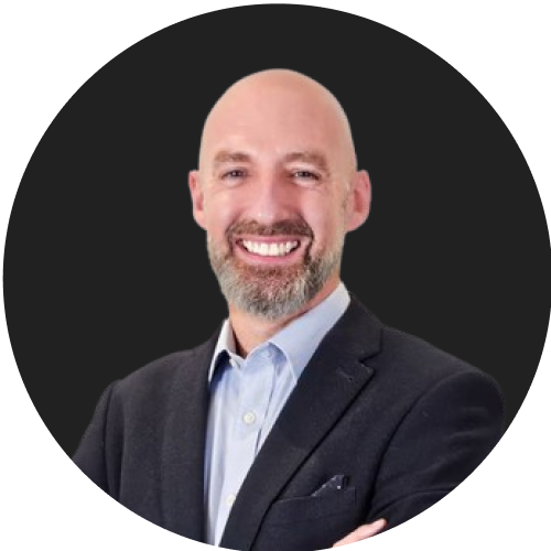 Smiling bald man with beard in business suit on black background