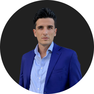 Young professional man in blue suit with confident expression against black background