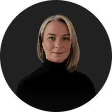 Professional portrait of a confident woman with short blonde hair and black turtleneck