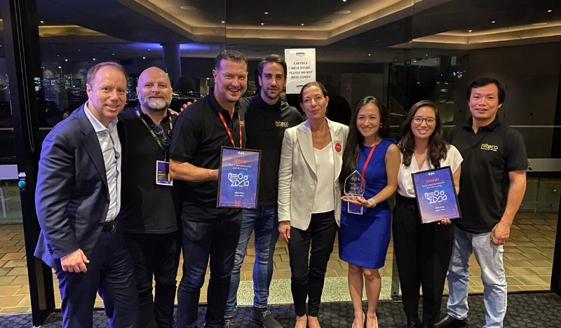 Team celebrates winning innovation awards at industry event with trophies and plaques