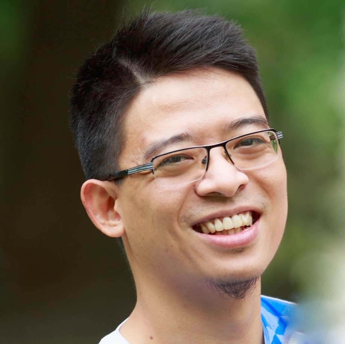 Smiling young man with glasses outdoors, technology professional profile