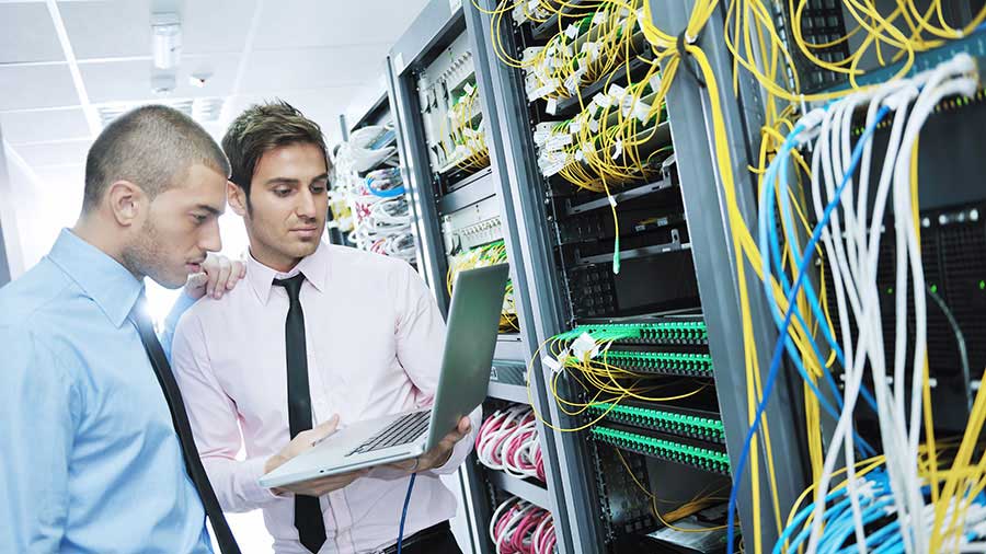 IT professionals troubleshooting network servers in a data center with cables
