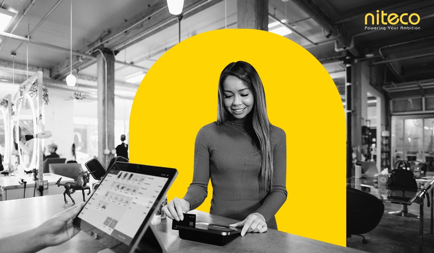 Young woman making payment with card at modern cashier, Niteco branding