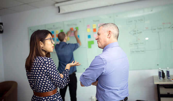 Team collaborating on Agile project planning with sticky notes on whiteboard
