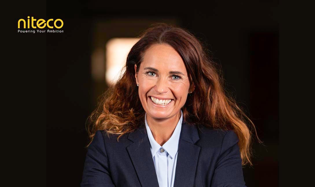 Smiling businesswoman in blazer representing Niteco's ambition and leadership
