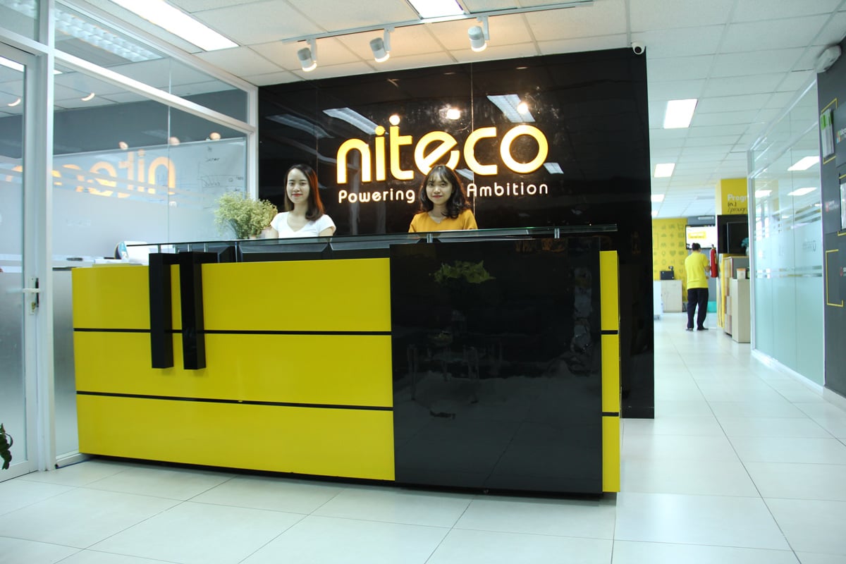 Niteco office reception with two women behind yellow and black desk