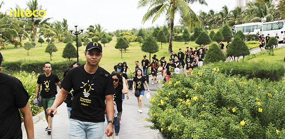 Alt text: Niteco team participating in a green outdoor corporate event walking on pathway