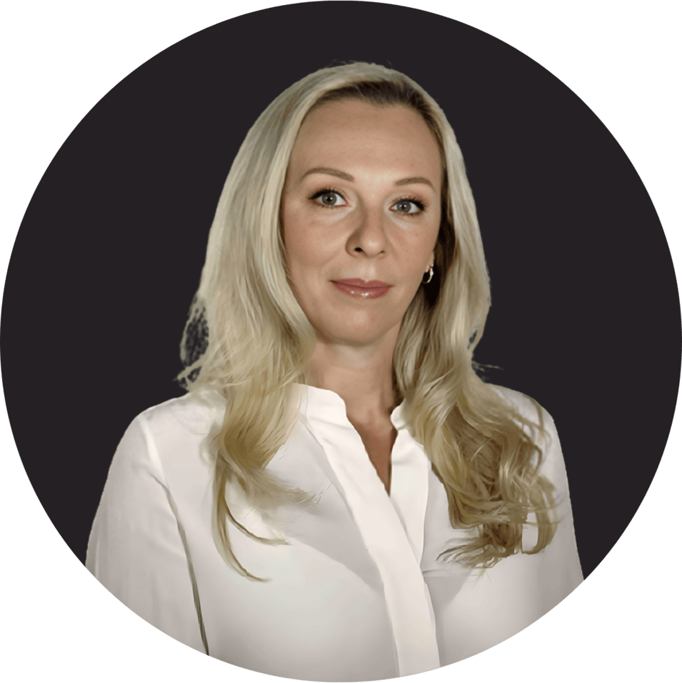 Blonde woman in white blouse with neutral expression on dark background