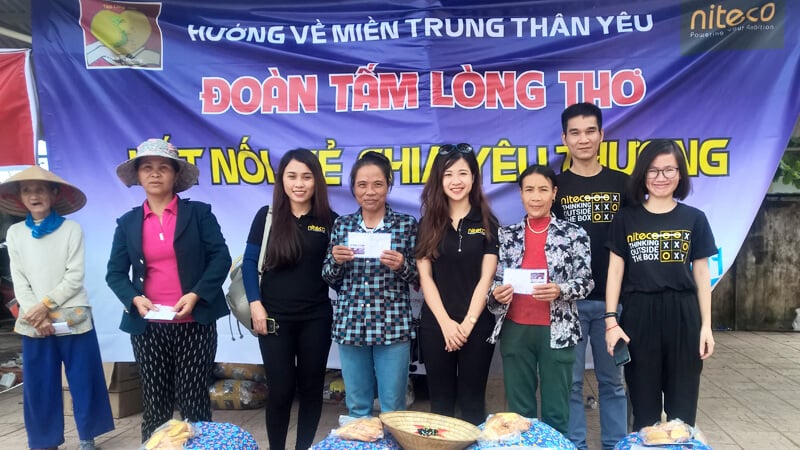 Volunteer group distributing aid to Central Vietnam with Niteco support banner